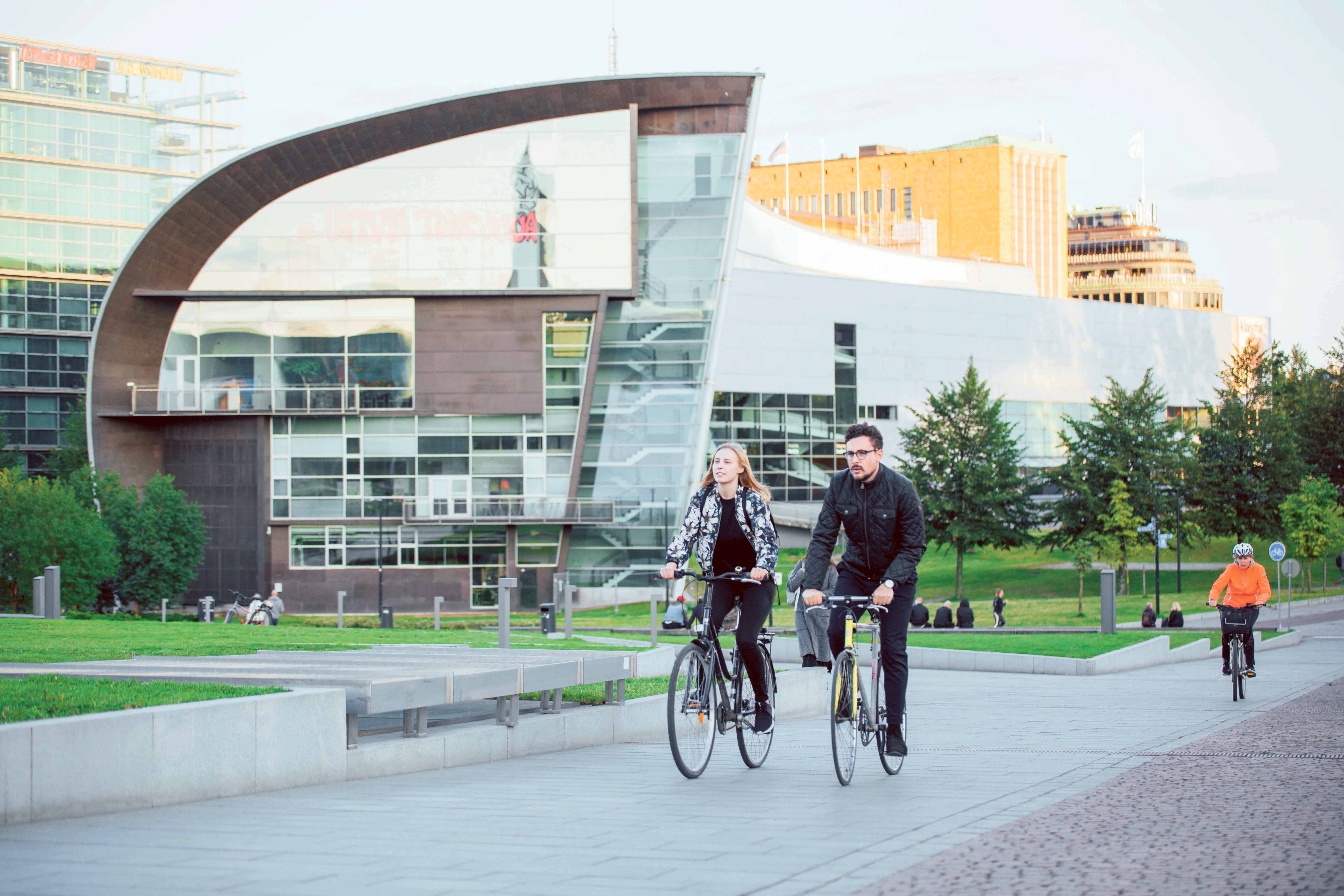 Two people cycling in an urban surrounding.